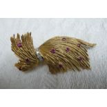 18 ct. gold feather brooch highlighted with rubies and a belt of diamonds - 23 grammes total -
