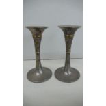 A pair of silver gilt candle sticks with decoration of flora & fauna to collars on circular