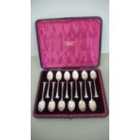 A cased set of twelve Victorian silver tea spoons with scallop shell and scroll handles - London