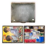 A large leather suitcase with wooden compartments filled with classic Lego bricks and pieces, from