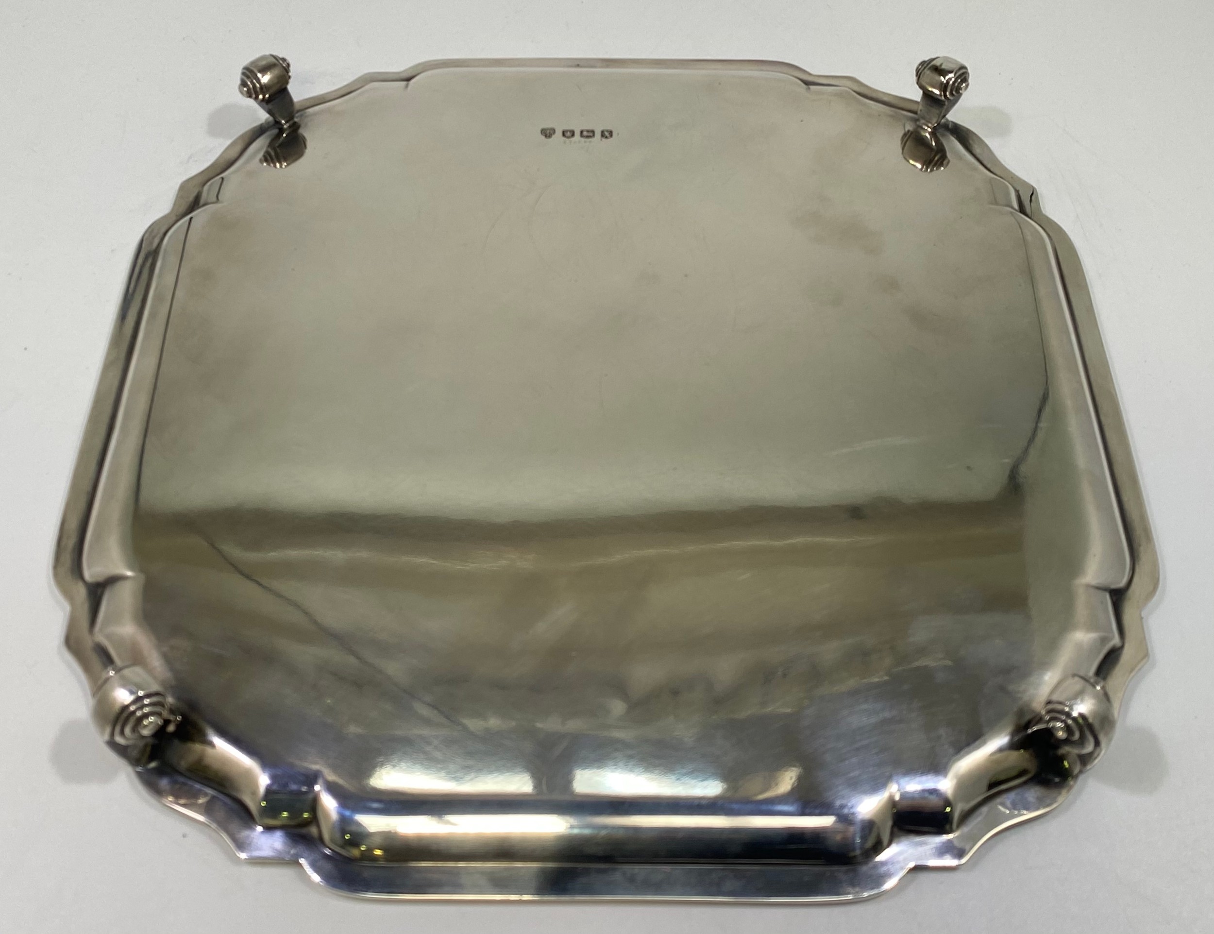 A ERII silver salver of square form with serpentine canted corners, pie-crust rim raised on four - Image 5 of 5
