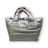 A Chanel navy and silver reversible quilted nylon cocoon tote handbag, with silver tone zip front
