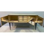 A mid-20th century Italian sideboard by Umberto Mascagni, with cream padded doors and sides, central