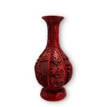 A Chinese carved simulated Cinnabar lacquer fluted vase with brass lining, the intricate sides