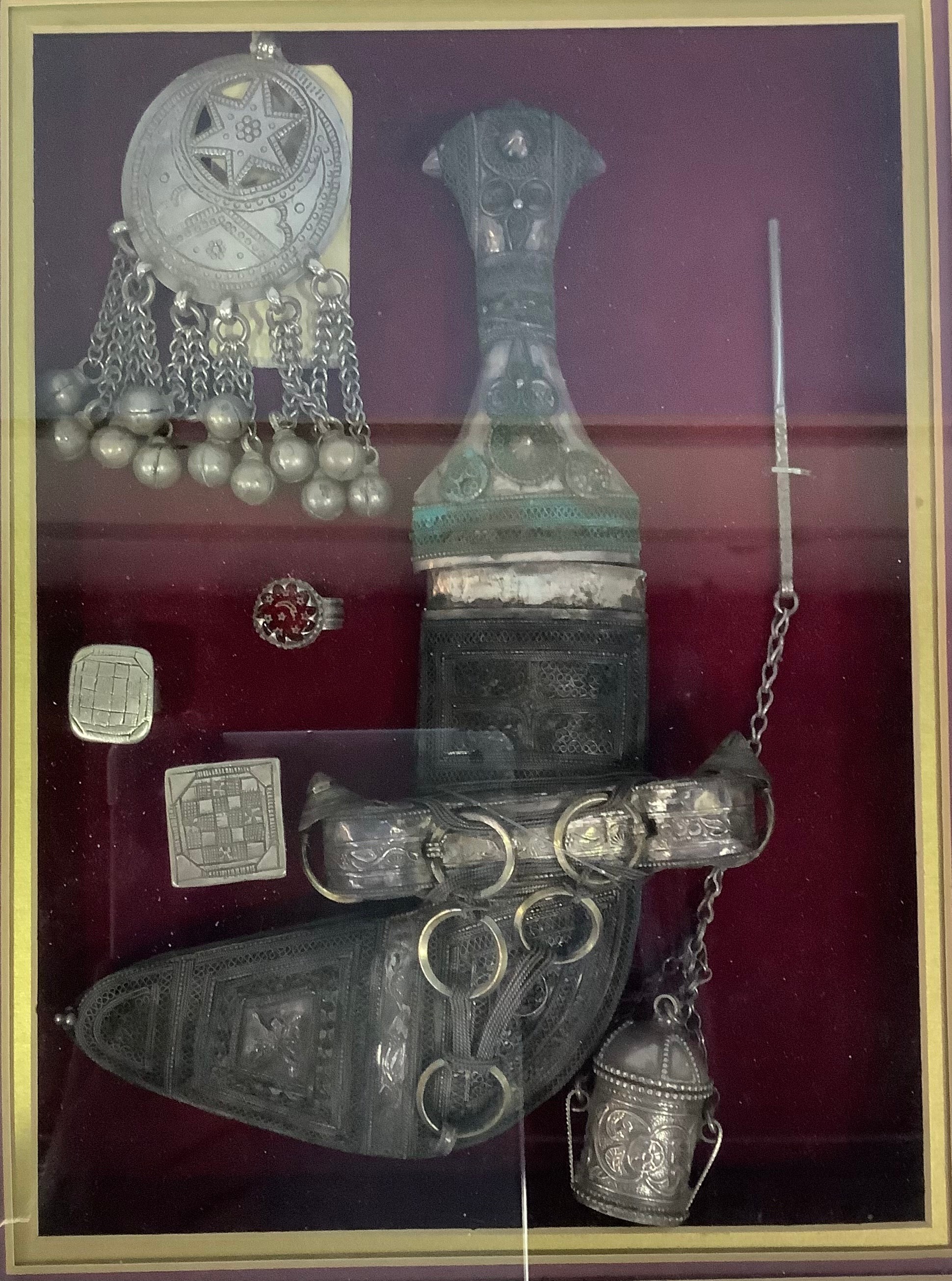 A collection of framed and mounted early 20th century Omani silver jewellery and collectables, - Image 2 of 2