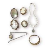 Three various cameo brooches, and a large oval shaped Mother of Pearl brooch, a silver bangle, a