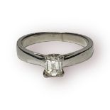 A platinum solitaire diamond ring, with an emerald cut diamond in a four claw setting, estimated