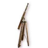 A brass telescope on folding wooden tripod swivel stand