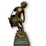 A patinated cast bronze figure of a boy wearing loincloth and carrying a basket, raised on stepped