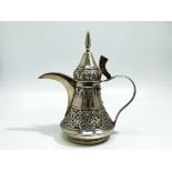 An Omani silver coffee pot, with continuous embossed decoration, finial, marked ‘13’ to base (