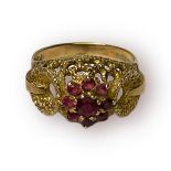 A 9ct yellow gold dress ring, set with 9 x round red coloured stones in a daisy style to the top, in