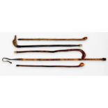 Five various walking sticks including one example made from a stained bamboo flute, modelled as a