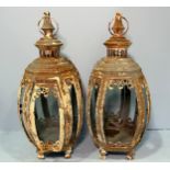 A pair of cream painted wrought iron and glass panel hanging garden lanterns of swelled octagonal