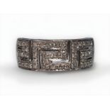 An 18ct white gold ring, with Greek key design to top set with small diamonds, gross weight