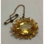 An antique high carat gold, probably 18ct, filigree brooch, centrally claw set with a large, faceted