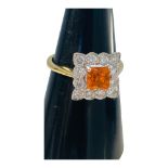 An 18ct yellow gold tangerine spessartite garnet and diamond cluster ring, claw set with a central