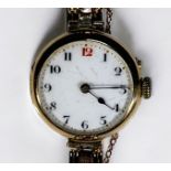 A ladies 15ct gold wristwatch, the white enamel dial with Arabic numerals denoting hours, on