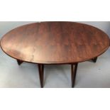 A mid-century rosewood oval drop leaf dining table, the top with square sectioned piano hinges to