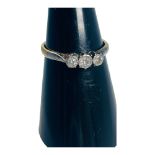 An 18ct gold three-stone diamond ring, the three Victorian cut diamonds are claw set in platinum,