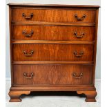 A reproduction mahogany chest of four long graduated drawers with brass handles, raised on shaped