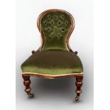 A Victorian stained walnut spoon-back nursing chair with green velvet upholstery, on turned supports