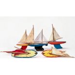 A collection of seven painted wooden pond yachts with rigged sails and metal keel, including,