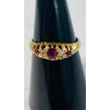 An 18ct yellow gold dress ring, set with 3 x faceted rubies, and 2 x old cut diamonds, in a gypsy