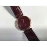 A ladies Must De Cartier quartz wristwatch, the plain dark rouge dial with gilt branding, housed