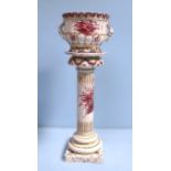 A Portugese pottery jardiniere on columns stand, decorated with pink flowers, 83cm
