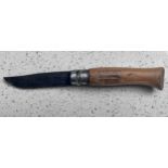 An Opinel folding pocket knife with 100mm single-edged steel blade and beechwood profiled branded