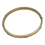 A 9ct gold hinged bangle, with screw top design, weighs 10.4 grams.