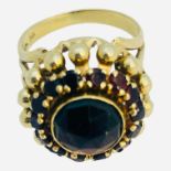 An 14ct yellow gold dress ring, set with a round faceted garnet to the centre, with 14 x small round