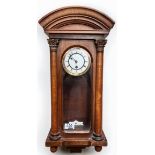 A walnut and beech cased Vienna wall clock with white enamel dial and pendulum, arched frieze