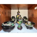 A pair of black ground cloisonne ginger jars and covers on wooden stands, 21cm high, and a similar