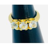 An 18ct yellow gold dress ring, set with three pale blue faceted stones in a claw setting, ring