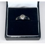 A platinum solitaire diamond ring, centrally bezel set with a round brilliant cut diamond, diamond