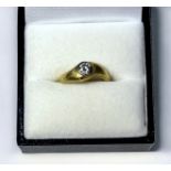 An 18ct yellow gold textured design solitaire diamond ring, the round brilliant cut diamond in a