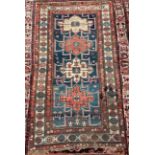 A hand-knotted tribal wool rug of Afshar design, worked with three guls to a blue ground within a