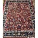 A hand-knotted wool garden carpet, with with a field of stylised flowers to deep red ground,
