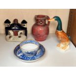 A Barnstaple pottery puzzle jug with incised rouge glaze, together with a Beswick standing duck with