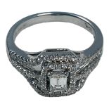 An 18ct white gold diamond ring, set with a central emerald cut diamond, measuring 5mm x 6mm,