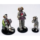 Three silvered figures of clowns by Mida’s, one holding a love heart, another playing an accordion