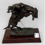 After Frederick Remington, 'The Broncho Buster,' patinated bronze figure of a cowboy and horse, on