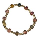 A 9ct yellow gold multi-coloured gemstone bracelet, set with 11 x various coloured faceted