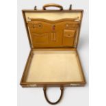 A vintage tan leather Gucci attaché case, with branded brass combination locks, and two leather