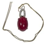 A 9ct yellow gold red cabochon cut pendant, on 9ct gold chain, bale set with small white faceted