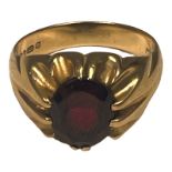 A gents 9ct gold dress ring, set with an oval-shaped red, faceted stone to the centre, weighs 4.6