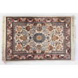 A small hand-knotted Persian rug, worked with a central medallion in garden with vases of flowers