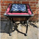 A Napoleonic themed pewter chess set with board, raised on ornate x-frame table, 51cm diameter