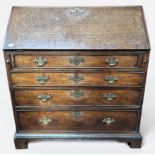 An 18th century oak bureau, with hinged sloped front enclosing central cupboard and pigeonholes,